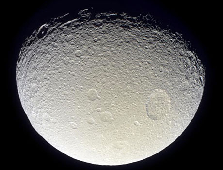 Image of Saturn's icy moon Tethys captured by NASA's Cassini spacecraft, showing its heavily cratered surface